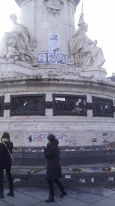 When news of the Charlie Hebdo killings spread, people began gathering in the Place de la République. Even now, the monument in the square is covered with flowers, candles, signs, banners and graffiti. (c) Dylan Horrocks