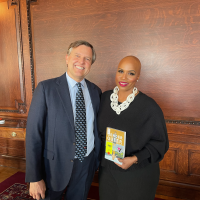 CBLDF Interim Director Jeff Trexler and Congresswoman Ayanna Pressley, holding a copy of Gender Queer at the Congressional Roundtable on Book Bans, in the Library of Congress